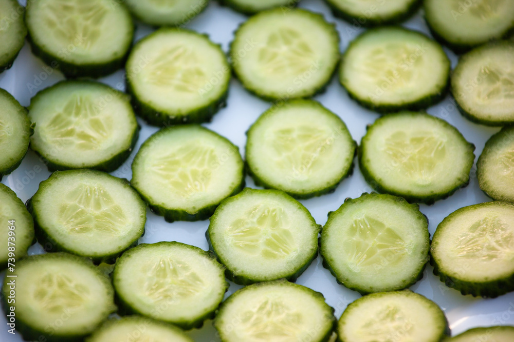 Background from green cucumber circles, top view. Fresh Cucumber sliced for publication, poster, calendar, post, screensaver, wallpaper, postcard, banner, cover, website. High quality photo Background from green cucumber circles, top view. Fresh Cucumber sliced for publication, poster, calendar, post, screensaver, wallpaper, postcard, banner, cover, website. High quality photo