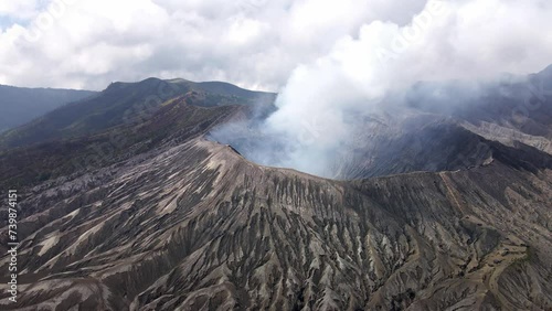 The awe of Mount Bromo's volcanic activity – a natural spectacle of billowing smoke and fiery eruptions in East Java, Indonesia. iconic vulcano, pacific ring of fire, aerial 4K drone footage photo