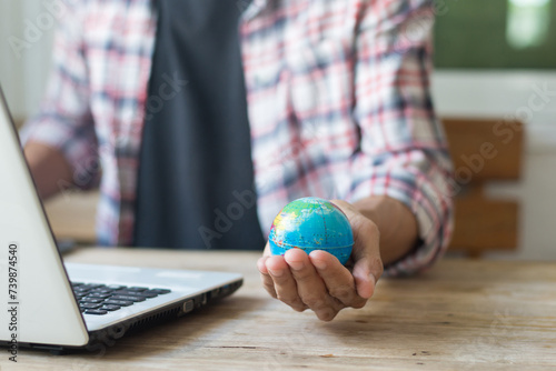 Man holding a globe while working online at home,work from home or concept.