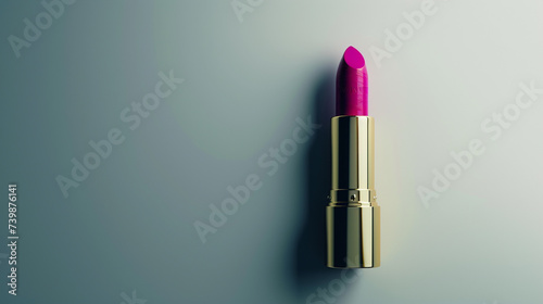A bold magenta lipstick on a light gray background, perfect for copy. The lipstick's vibrant color is offset by its simple, elegant packaging.