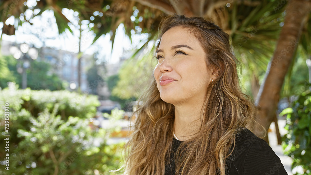 Attractive young hispanic woman, full of confidence, beaming with a radiant smile, standing outdoors in the green park having fun, her eyes cheerfully looking to the side Attractive young hispanic woman, full of confidence, beaming with a radiant smile, standing outdoors in the green park having fun, her eyes cheerfully looking to the side