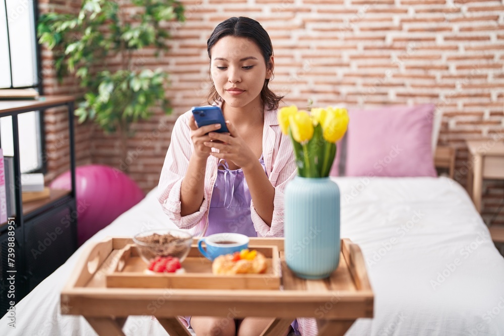 Young hispanic woman make photo by smartphone to gift breakfast at bedroom Young hispanic woman make photo by smartphone to gift breakfast at bedroom