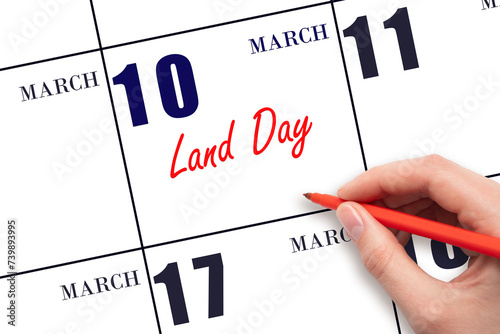 March 10. Hand writing text Land Day on calendar date. Save the date. photo