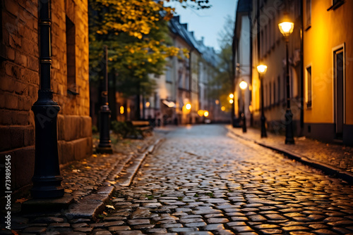 Old street with cobblestone and lanterns at night in Riga, Latvia