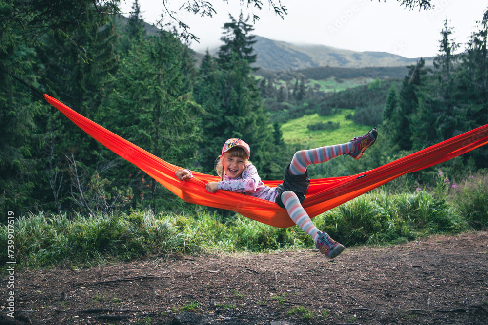 little cute girl at hammock in mountains