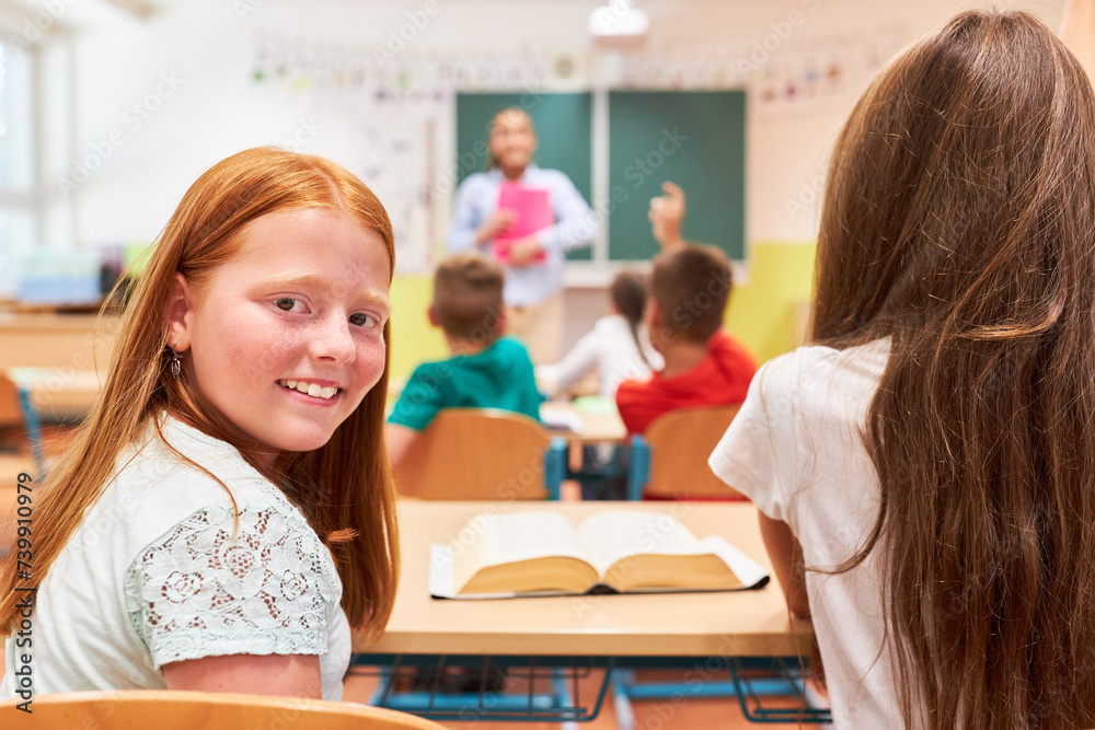 Smiling girl sitting with classmate in school Smiling girl sitting with classmate in school