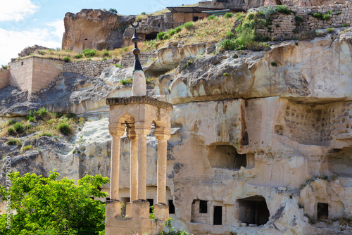 Minaret of the Old Kaya Mosque. Seljuk period. Caves city at background. Cavusin (Necsehir), Cappadocia, Turkey photo