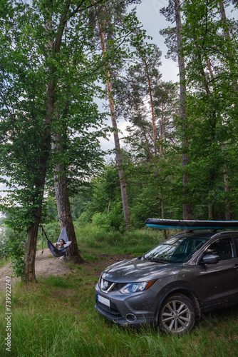 woman laying in hammock supboard on roof of car