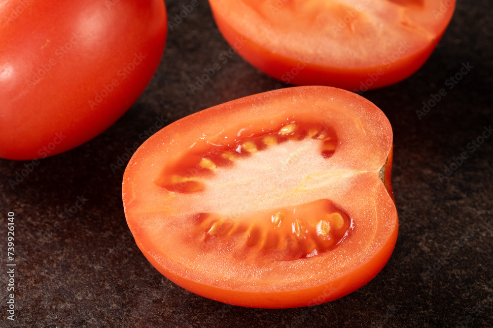 Close-up of freshly sliced tomato on elegant black background Close-up of freshly sliced tomato on elegant black background