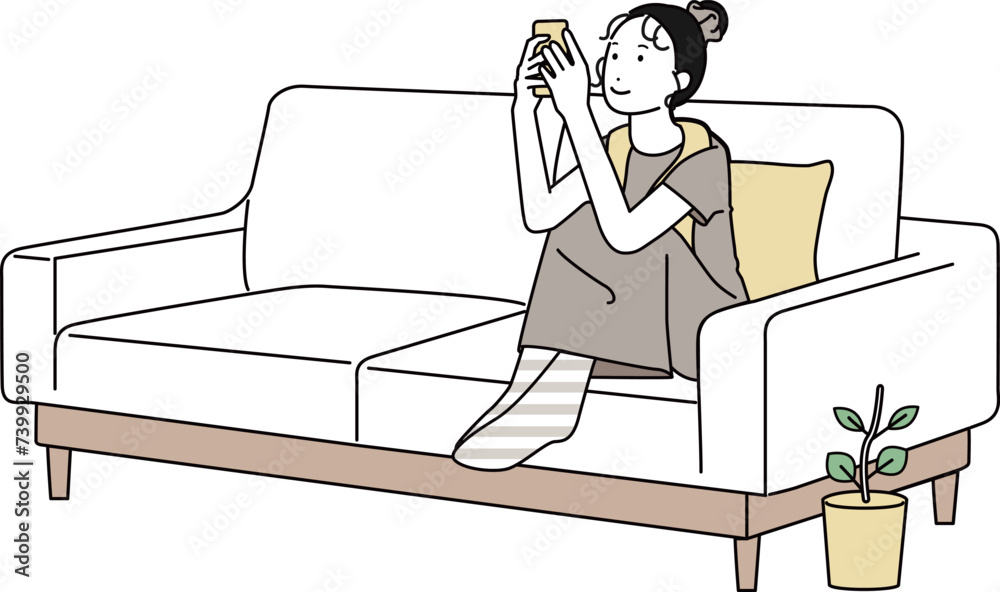 家のソファでスマホを触る女性