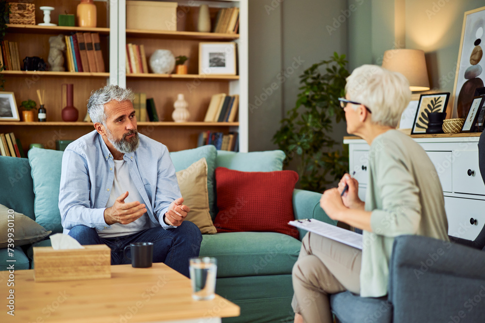 A mentally exhausted senior adult man explaining his problems to his psychotherapist, sitting in the doctor's office A mentally exhausted senior adult man explaining his problems to his psychotherapist, sitting in the doctor's office