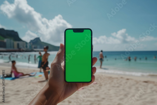 Mockup of an iPhone with a green screen, hand holding an iPhone, on the beach