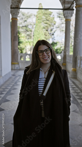 A smiling young woman with glasses in a historical istanbul palace corridor, displaying elegance and tourism vibes