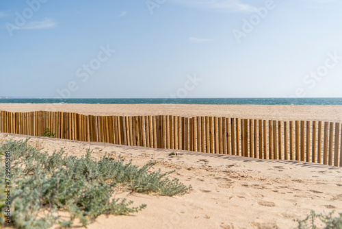 Sand beach with sea behind, dune fencing in wood, dune construction and strengthening 