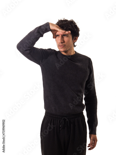 Man in black shirt shielding eyes while gazing into the distance