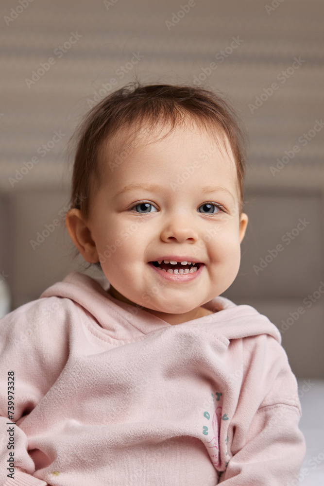 Cute little baby girl smiling in pink shirt in bedroom Cute little baby girl smiling in pink shirt in bedroom