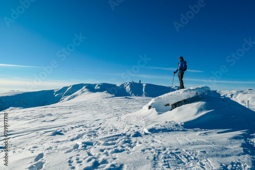 Man in snowshoes on snow covered mountains of Kor Alps, Lavanttal Alps, Carinthia Styria, Austria. Winter wonderland in Austrian Alps. Snow shoe tourism. Looking at summit peak Grosser Speikogel