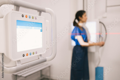 Medical professional standing by digital x-ray equipment photo