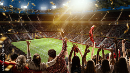 Back view. Football, soccer fans cheering their team with colorful scarfs at crowded stadium at evening time during game. Sport match. Concept of competition, leisure time, emotions, live sport event
