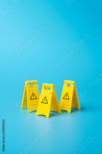 Warning yellow clamshell floor signs. Identify dangers and threats. On the approach to a difficult challenge. Deal with problems. Solve the problem with knowledge of the entire situation.