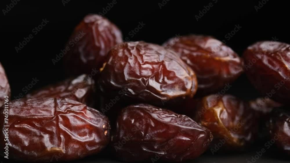 Dried dates, dried fruits on a black background close-up.