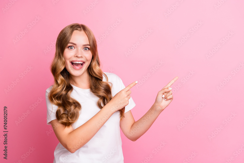 Photo of young excited shocked adorable woman wear white trendy t shirt direct fingers proposition isolated on pink color background Photo of young excited shocked adorable woman wear white trendy t shirt direct fingers proposition isolated on pink color background