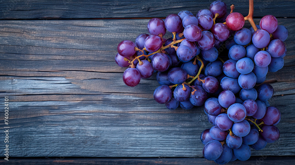 top view a bunch of purple grapes on a wooden background top view a bunch of purple grapes on a wooden background