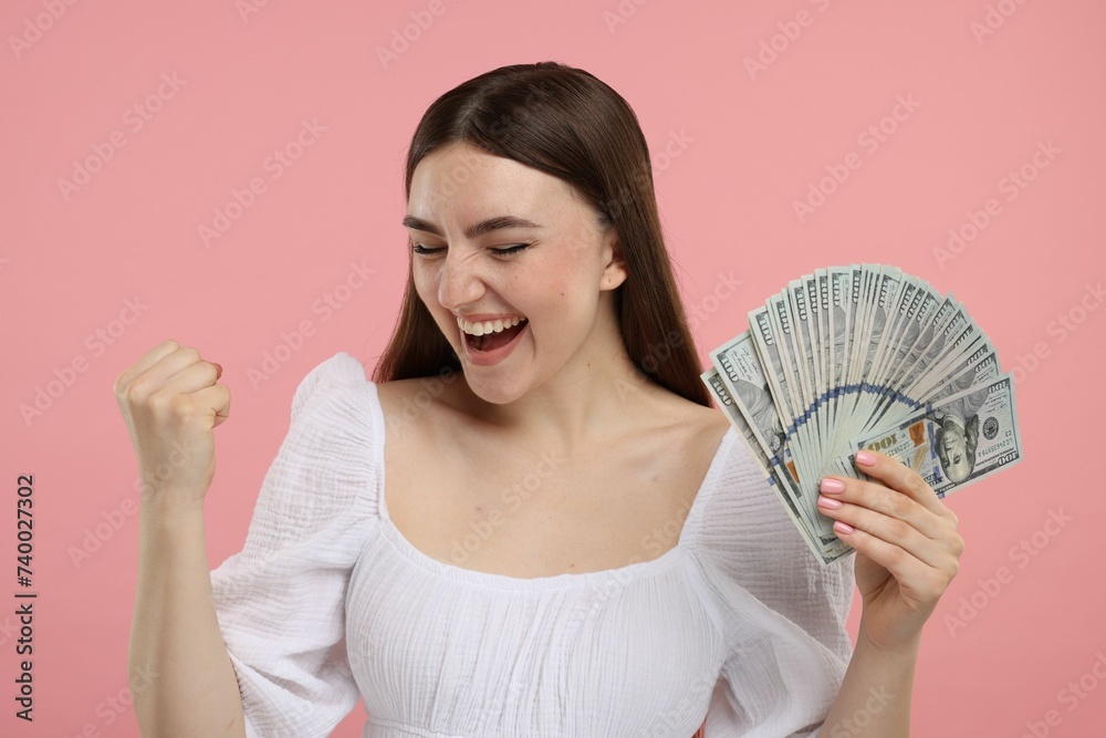 Excited woman with dollar banknotes on pink background Excited woman with dollar banknotes on pink background