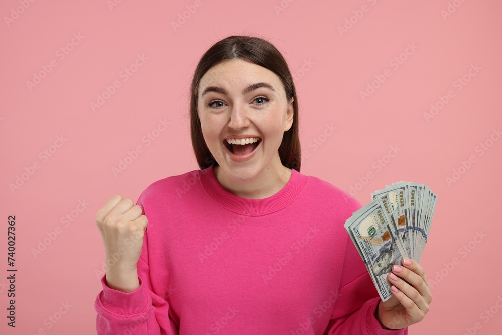 Happy woman with dollar banknotes on pink background
