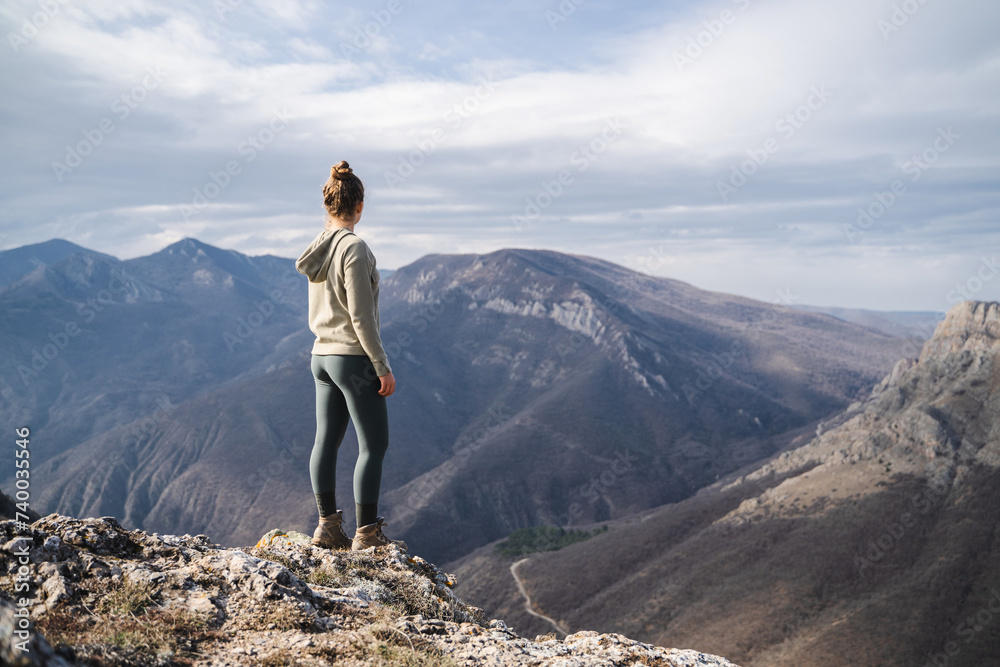 Hiker girl on the mountain top in trip, sport and active life concept, young girl enjoying view on peak of sunny mountain, tourist traveler on background view mockup Hiker girl on the mountain top in trip, sport and active life concept, young girl enjoying view on peak of sunny mountain, tourist traveler on background view mockup