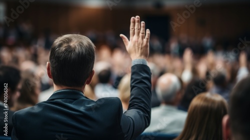 Businessman raising his hand during a seminar, business meeting or conference.