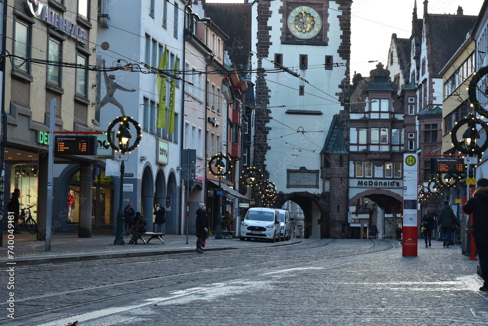Historic City Gate Tower and Street Decorated with Lights in Freiburg, Germany
