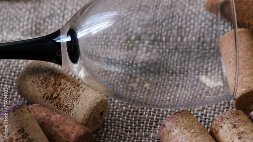 close-up of an empty glass goblet and a pile of wine bottle caps rotating. wine cellar concept. alcohol market, drinking wine photo