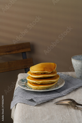 A stack of pancakes with honey on a vintage plate on the table. Breakfast. (ID: 740062991)