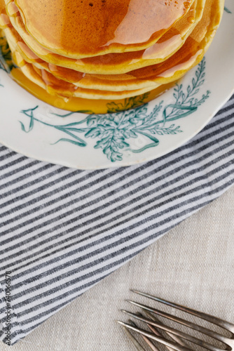 A stack of pancakes with honey on a vintage plate on the table. Breakfast. (ID: 740066578)