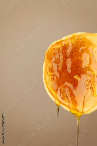 One pancake in honey on a brown background (ID: 740068103)