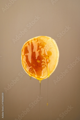 One pancake in honey on a brown background (ID: 740068500)