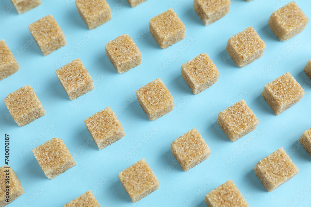 Brown sugar cubes on light blue background Brown sugar cubes on light blue background