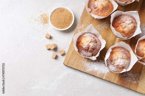 Delicious muffins on light table, flat lay. Space for text