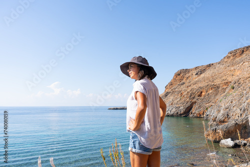 Latin woman enjoying a beautiful day of exploring and hiking at the end of summer on a small Greek island by the sea © Alberto Marrupe