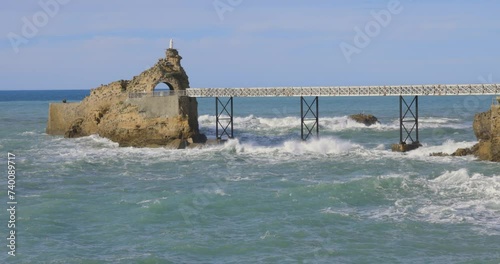 Establashing shot of rocher de la vierge in biarritz on the french coast of the atlantic ocean in the basque country photo