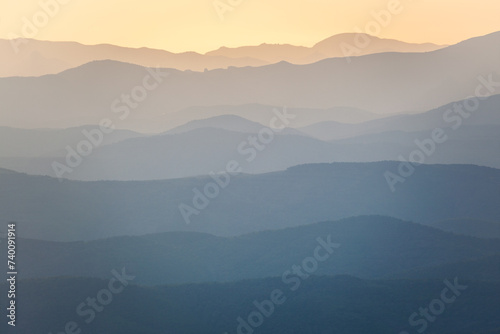 Landscape. Mountain slopes in the mist at sunset
