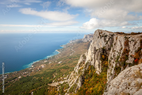 Landscape, high mountains in the clouds towering above the sea.