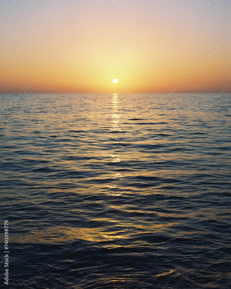 Obraz premium Sunrise over calm ocean horizon (film photography)