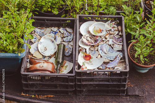 Artistic detail of a collection of broken interesting colorful broken ceramic and dishes used as decoration, in a box, with random items. Creative decoration ideas.