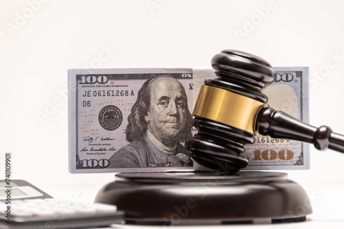 An isolated image of a judge's gavel on a stack of cash with a calculator, signifying legal fines or bail.