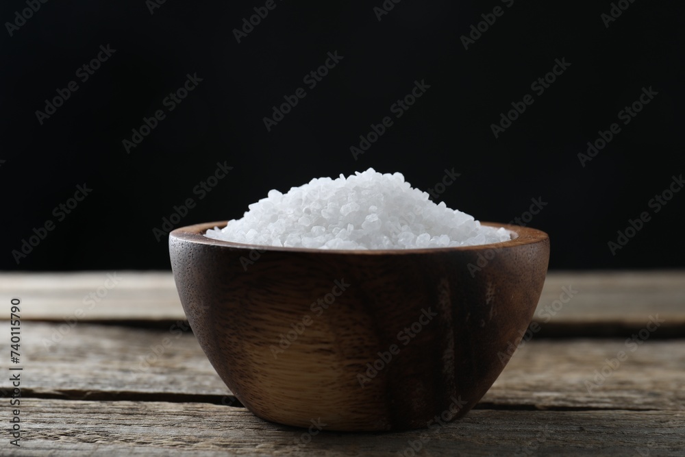 Organic salt in bowl on wooden table, closeup Organic salt in bowl on wooden table, closeup