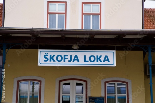 Scenic close up view of sign at railway station of Slovenian City of Skofja Loka on a cloudy summer day. Photo taken August 9th, 2023, Skofja Loka, Slovenia.