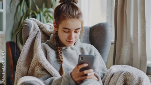 Serene Young Woman Using Smartphone in Cozy Armchair