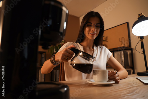 Young businesswoman pouring...